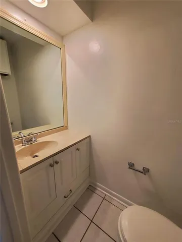 a bathroom with a granite countertop toilet and a sink
