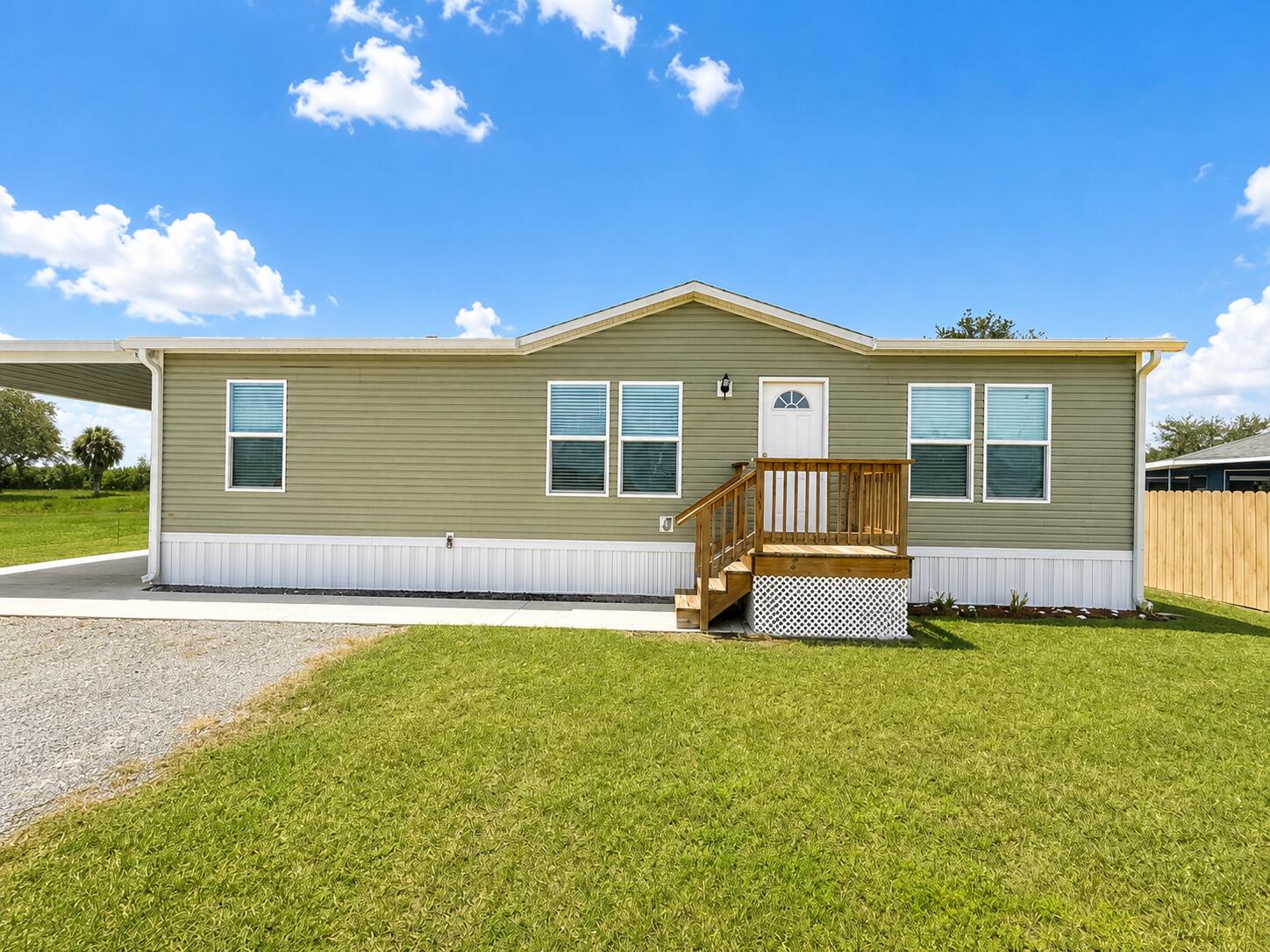 1121 Orange Loop Okeechobee, FL 34974 - Photo 1 of 33 Sunny Manufactured Home with Porch