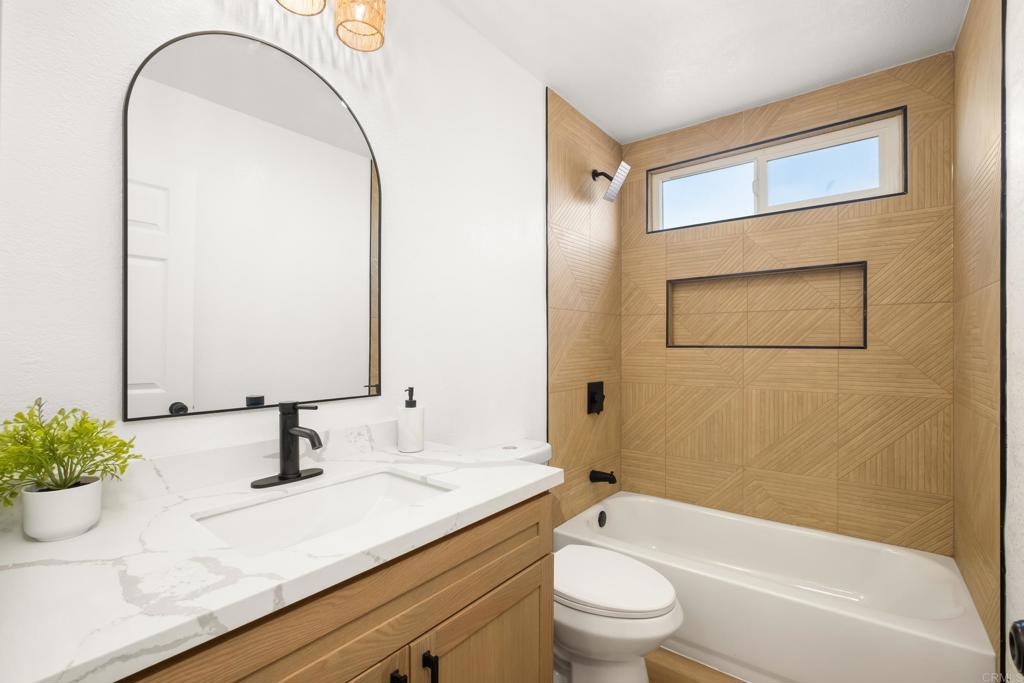552 Felicita Avenue Spring Valley, CA 91977 - Photo 16 of 44 a bathroom with a granite countertop sink a toilet and shower