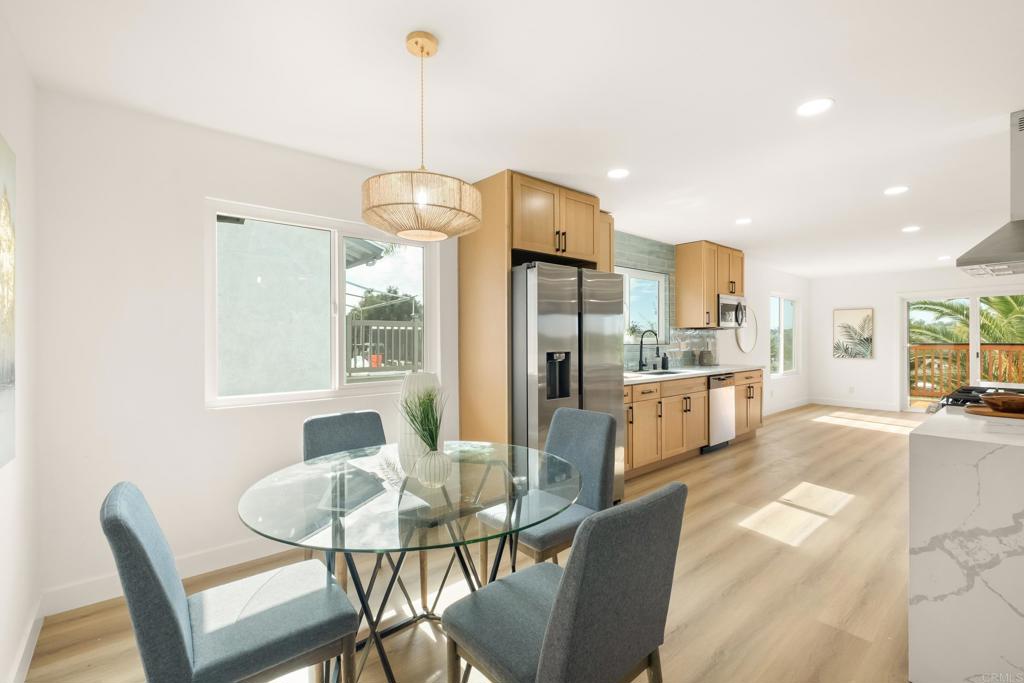 552 Felicita Avenue Spring Valley, CA 91977 - Photo 5 of 44 a kitchen with stainless steel appliances kitchen island granite countertop a dining table chairs and a refrigerator