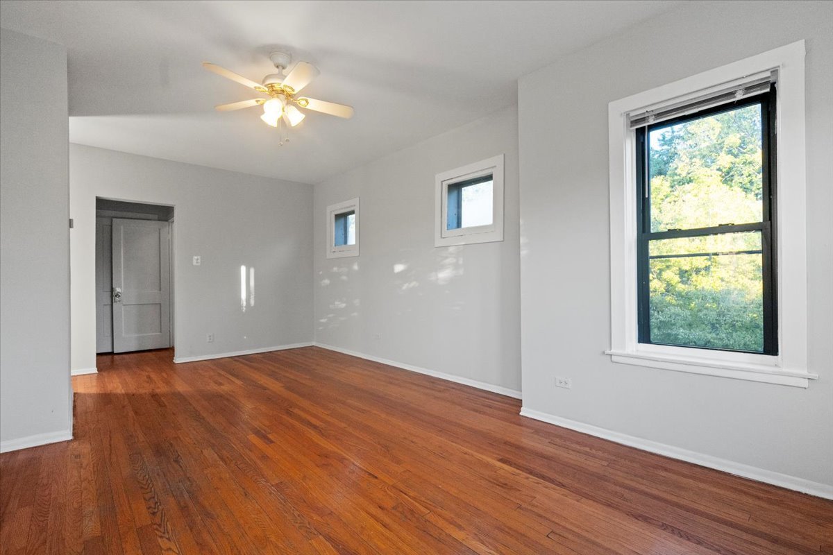 6700 South Merrill Avenue, Unit 3E Chicago, IL 60649 - Photo 4 of 12 a view of empty room with wooden floor and fan