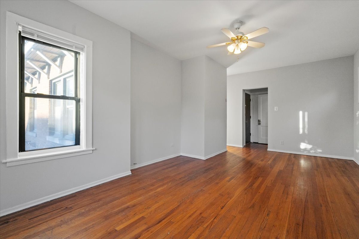 6700 South Merrill Avenue, Unit 3E Chicago, IL 60649 - Photo 10 of 12 a view of empty room with wooden floor and fan