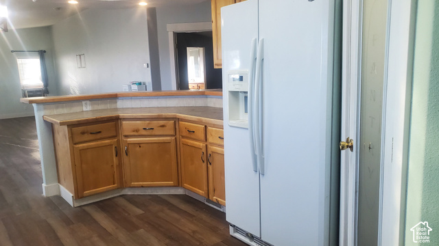 1055 West Ashby Road Delta, UT 84624 - Photo 14 of 50 Kitchen featuring wood-finish flooring, wood cabinetry with dark hardware, a white side-by-side refrigerator, and a pantry with a brass doorknob