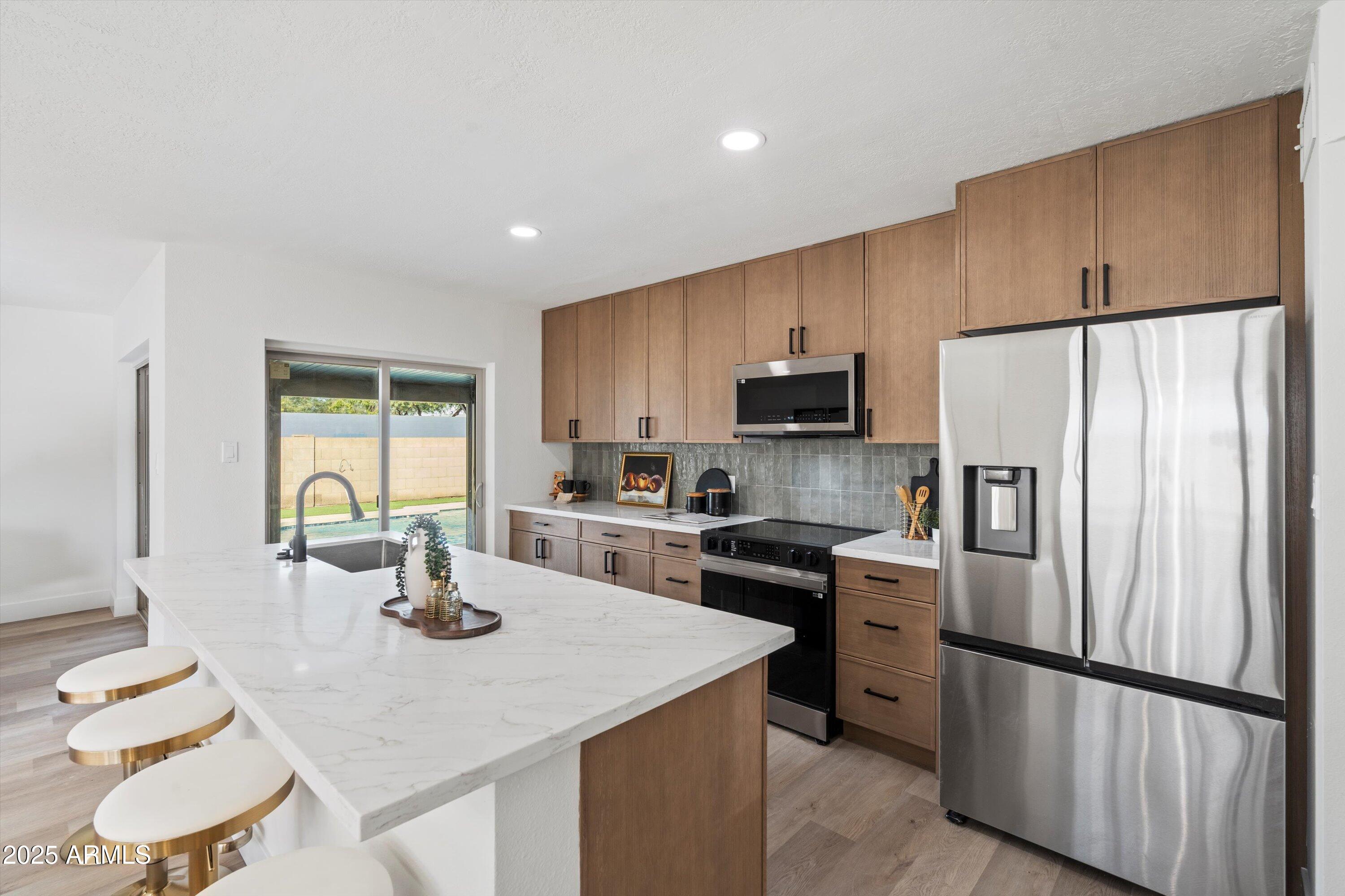 a kitchen with a refrigerator a stove a sink dishwasher and wooden cabinets with wooden floor