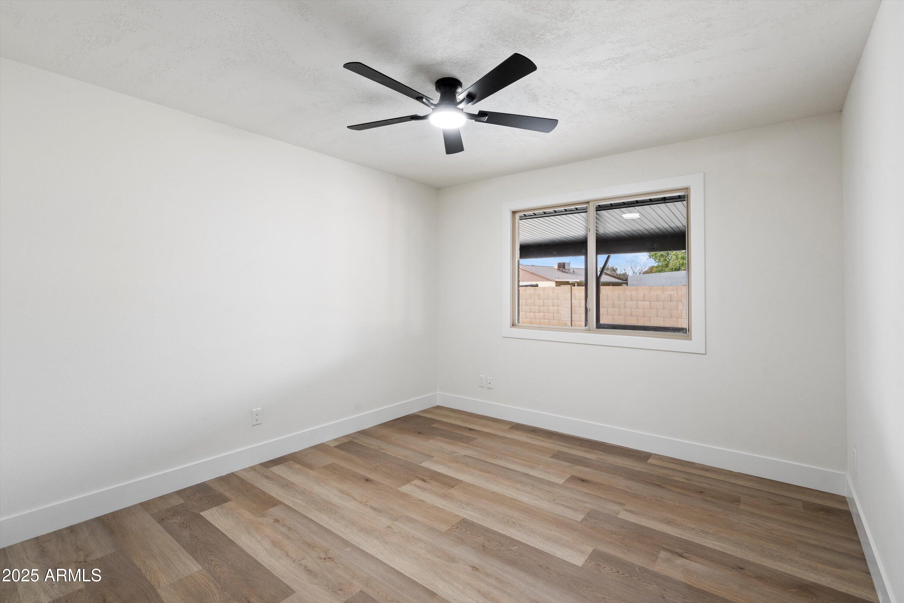 2116 East Colgate Drive Tempe, AZ 85283 - Photo 26 of 29 an empty room with wooden floor and ceiling fan