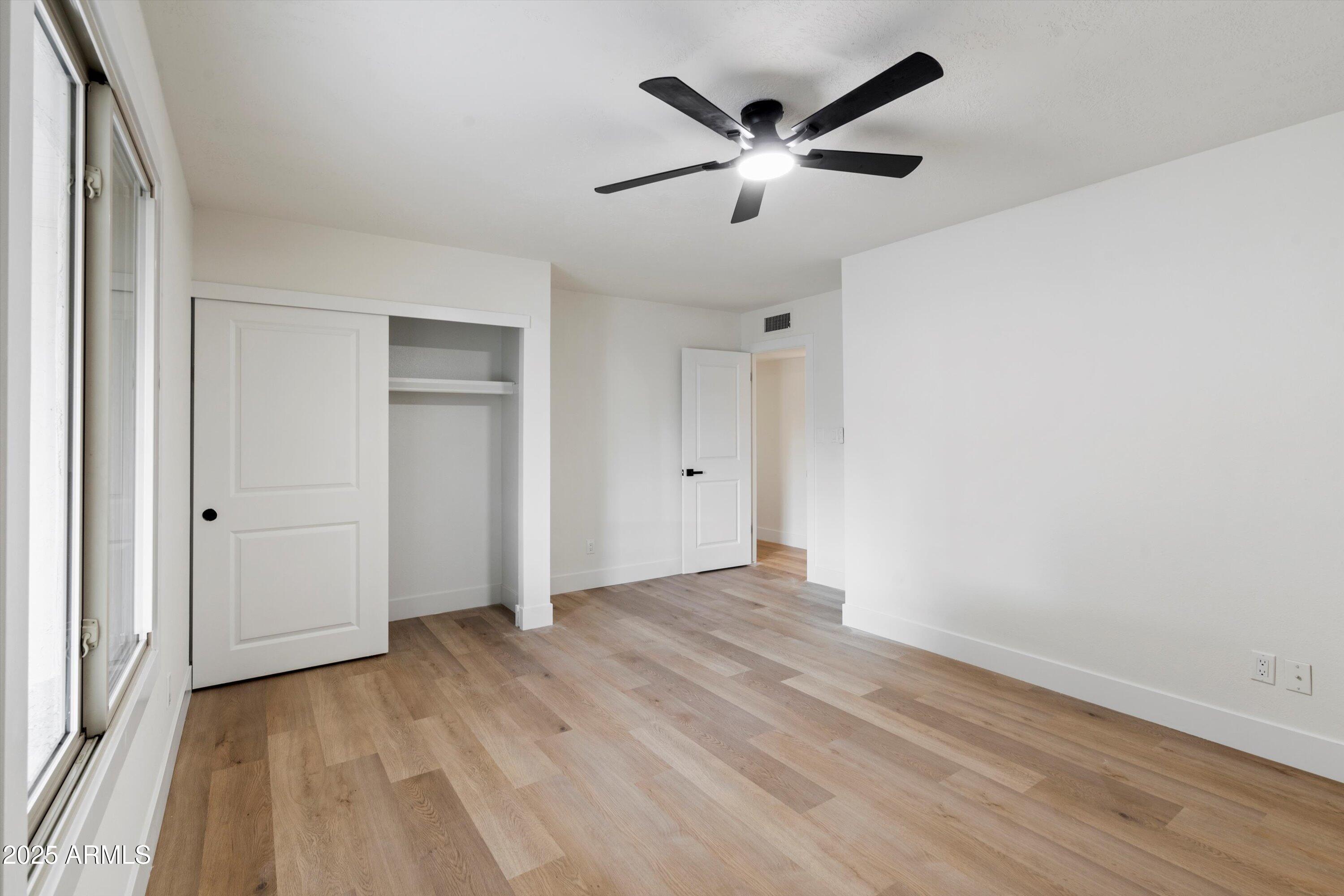 2116 East Colgate Drive Tempe, AZ 85283 - Photo 29 of 29 an empty room with wooden floor and windows
