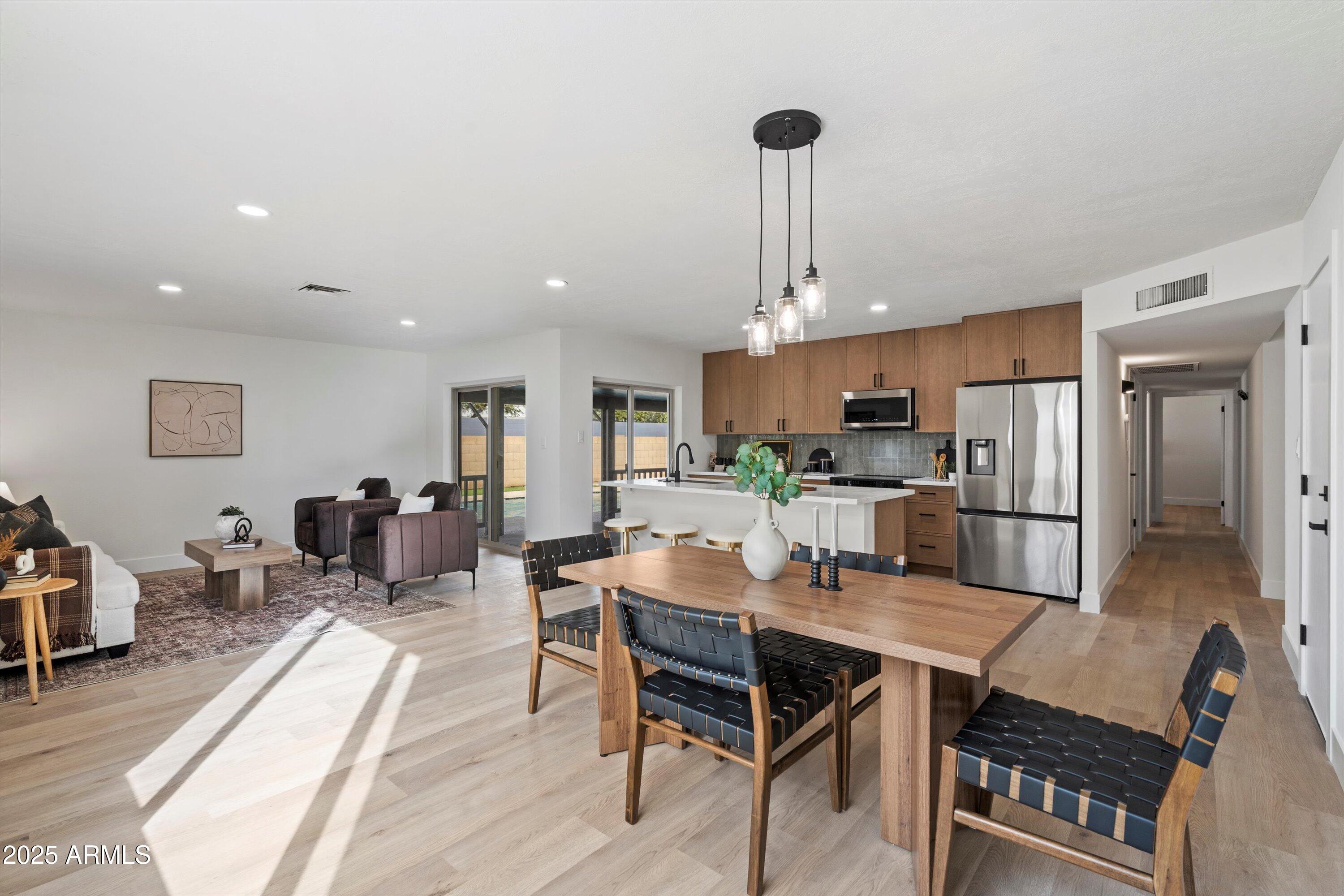 2116 East Colgate Drive Tempe, AZ 85283 - Photo 8 of 29 a dining room with stainless steel appliances kitchen island granite countertop a dining table chairs and a refrigerator