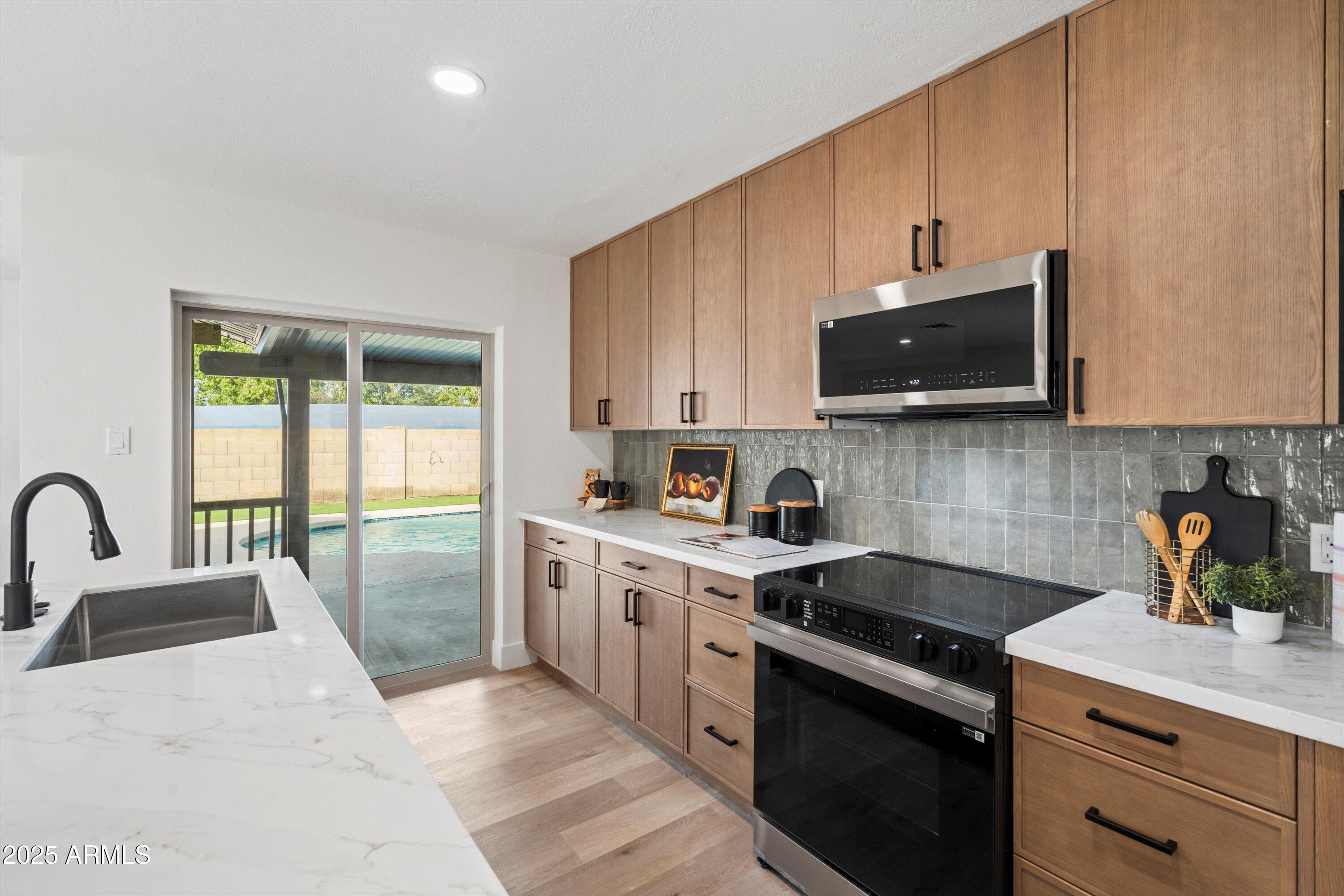 2116 East Colgate Drive Tempe, AZ 85283 - Photo 9 of 29 a kitchen with stainless steel appliances a sink a stove a microwave a sink a refrigerator and cabinets