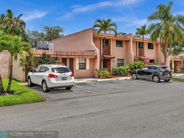 a white house covered with tall trees