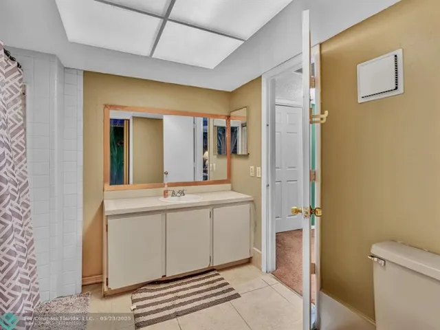 a spacious bathroom with a granite countertop sink and a mirror