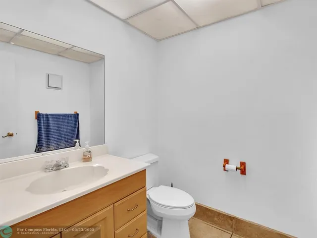 a bathroom with a sink vanity mirror and toilet
