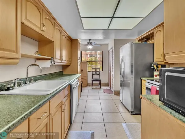 a kitchen with granite countertop a sink a counter top space and stainless steel appliances