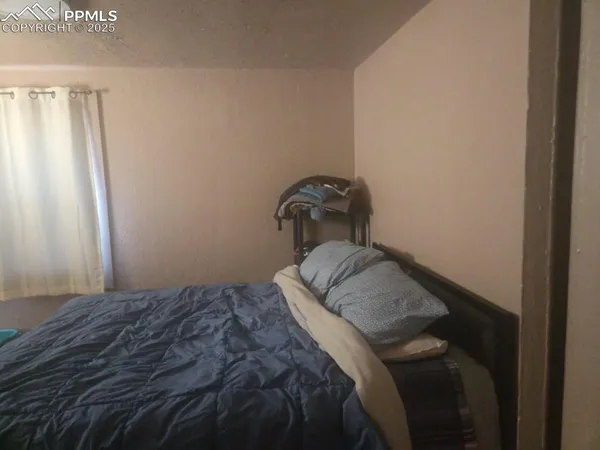a bedroom with a bed and hardwood