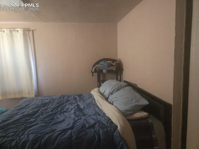 a bedroom with a bed and hardwood