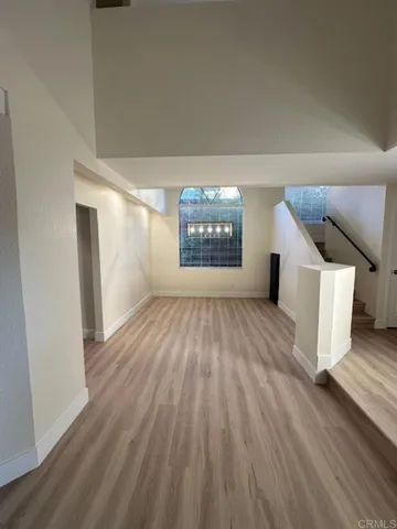 a view of empty room with wooden floor and fireplace