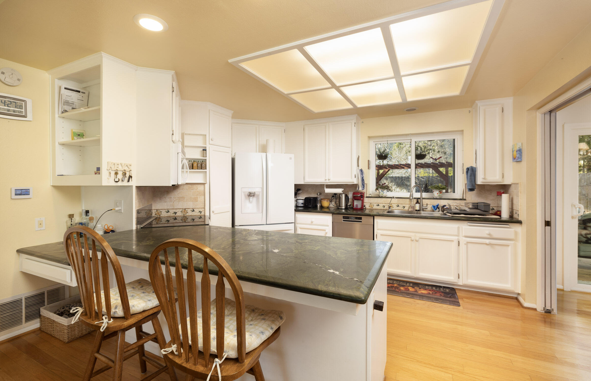 1539 Meadow Circle Carpinteria, CA 93013 - Photo 12 of 21 a kitchen with stainless steel appliances granite countertop a stove top oven a sink a dining table and chairs with wooden floor