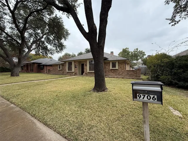a view of a house with a tree in front of it