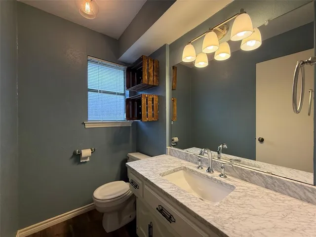a bathroom with a sink a toilet and mirror
