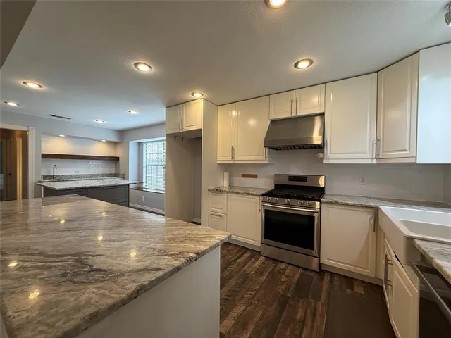 a kitchen with stainless steel appliances granite countertop a stove a sink and a refrigerator