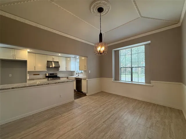 a large kitchen with kitchen island a stove a sink dishwasher a oven with wooden floor and cabinets