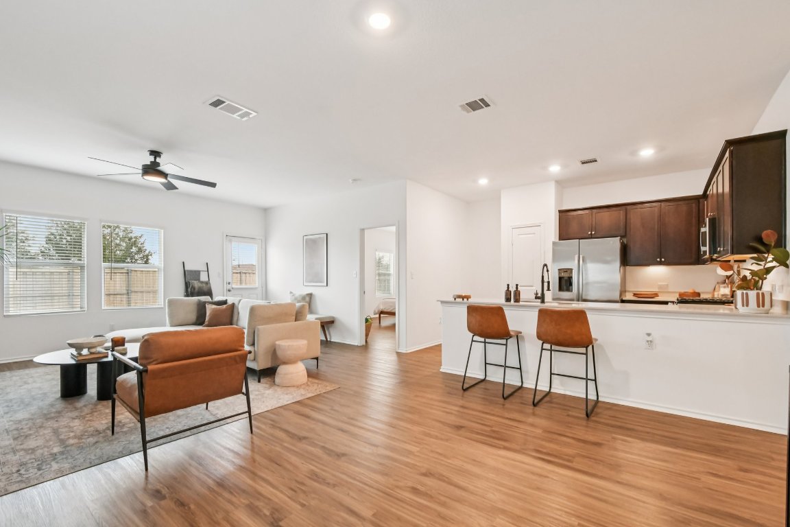 117 Badillo Way Bastrop, TX 78602 - Photo 9 of 40 a living room with furniture wooden floor and a kitchen view