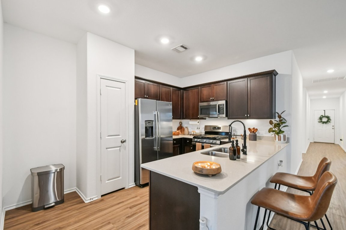 117 Badillo Way Bastrop, TX 78602 - Photo 16 of 40 a kitchen with stainless steel appliances kitchen island granite countertop a refrigerator and a stove top oven