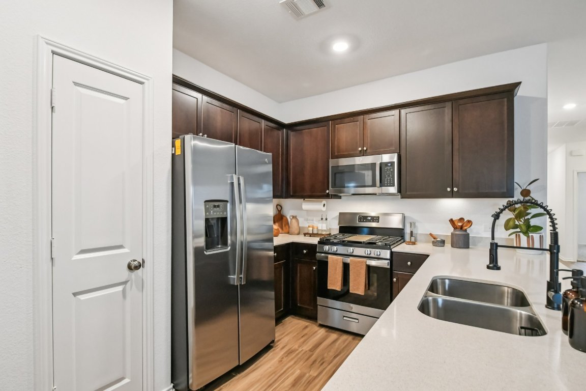 117 Badillo Way Bastrop, TX 78602 - Photo 17 of 40 a kitchen with stainless steel appliances granite countertop a refrigerator and a stove top oven