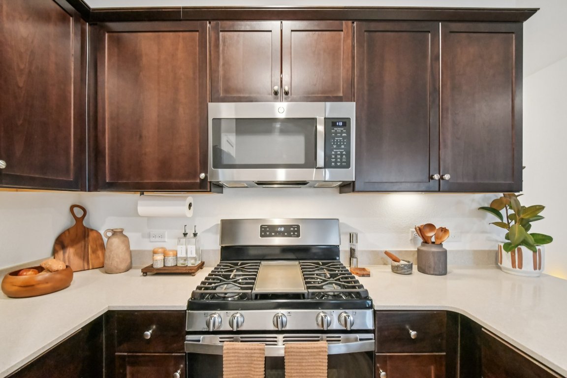 117 Badillo Way Bastrop, TX 78602 - Photo 19 of 40 a kitchen with granite countertop cabinets stove top oven and microwave