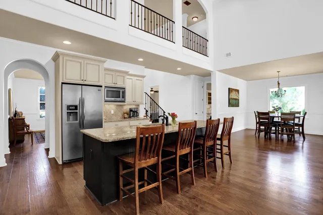 a dining room with furniture floor to ceiling window and wooden floor