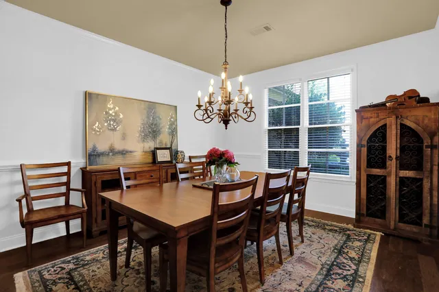 a dining room with furniture a chandelier and wooden floor