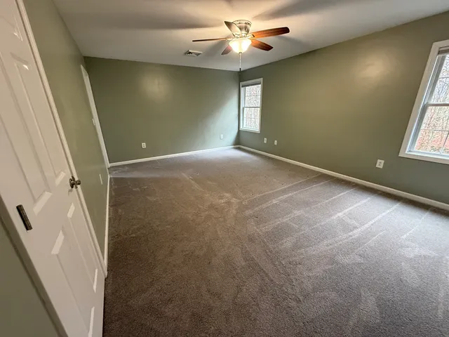 a view of a room with a ceiling fan and a window