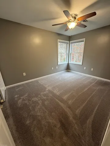 en empty room with windows and ceiling fan view