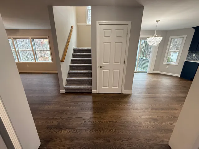 a kitchen with a sink stainless steel appliances wooden floor and refrigerator