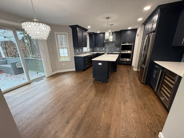 a large kitchen with stainless steel appliances granite countertop a sink stove and refrigerator