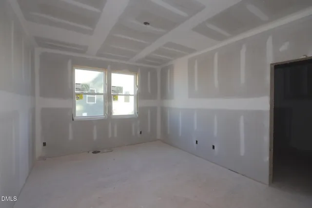 a view of an empty room with a fireplace and a window