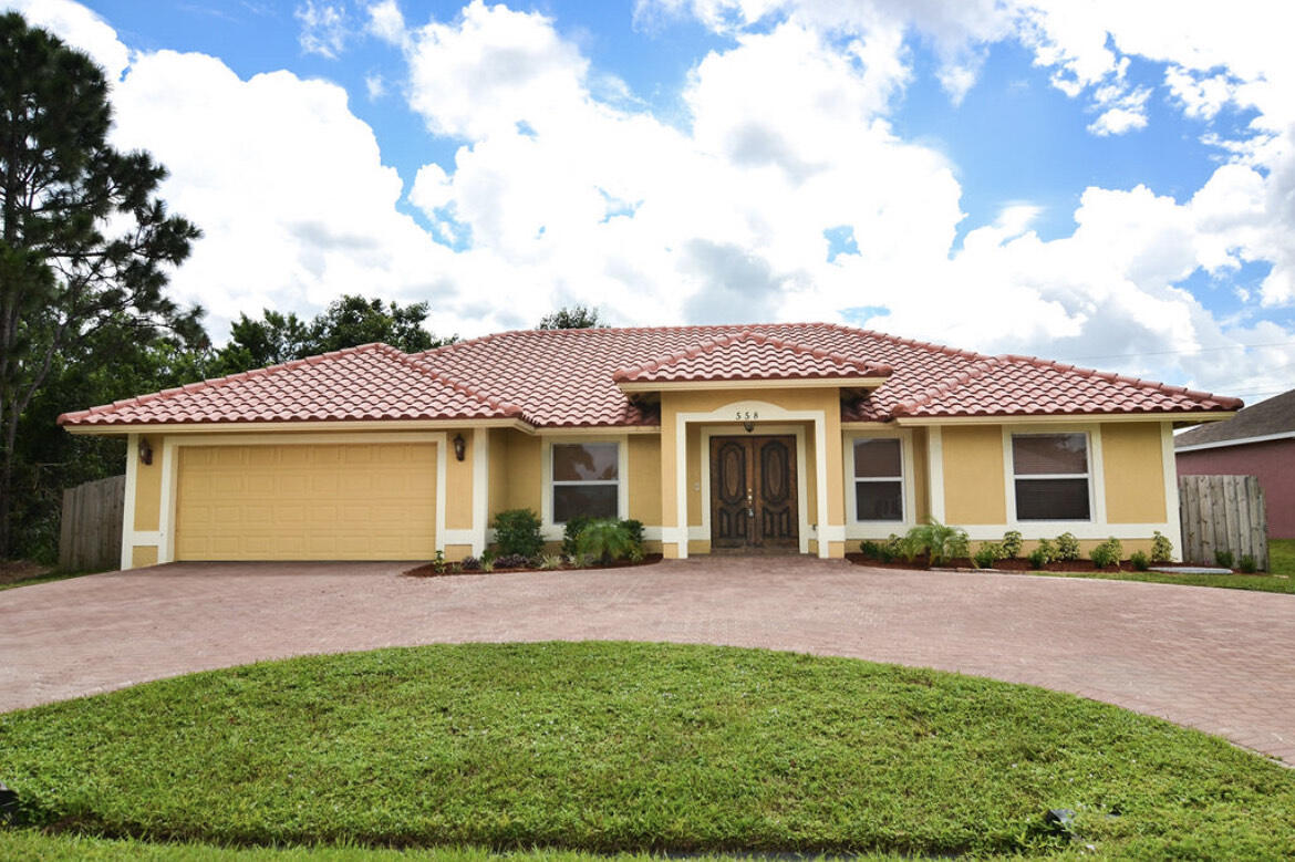 558 Southwest Colleen Avenue Port St. Lucie, FL 34983 - Photo 1 of 8 a front view of a house with a garden