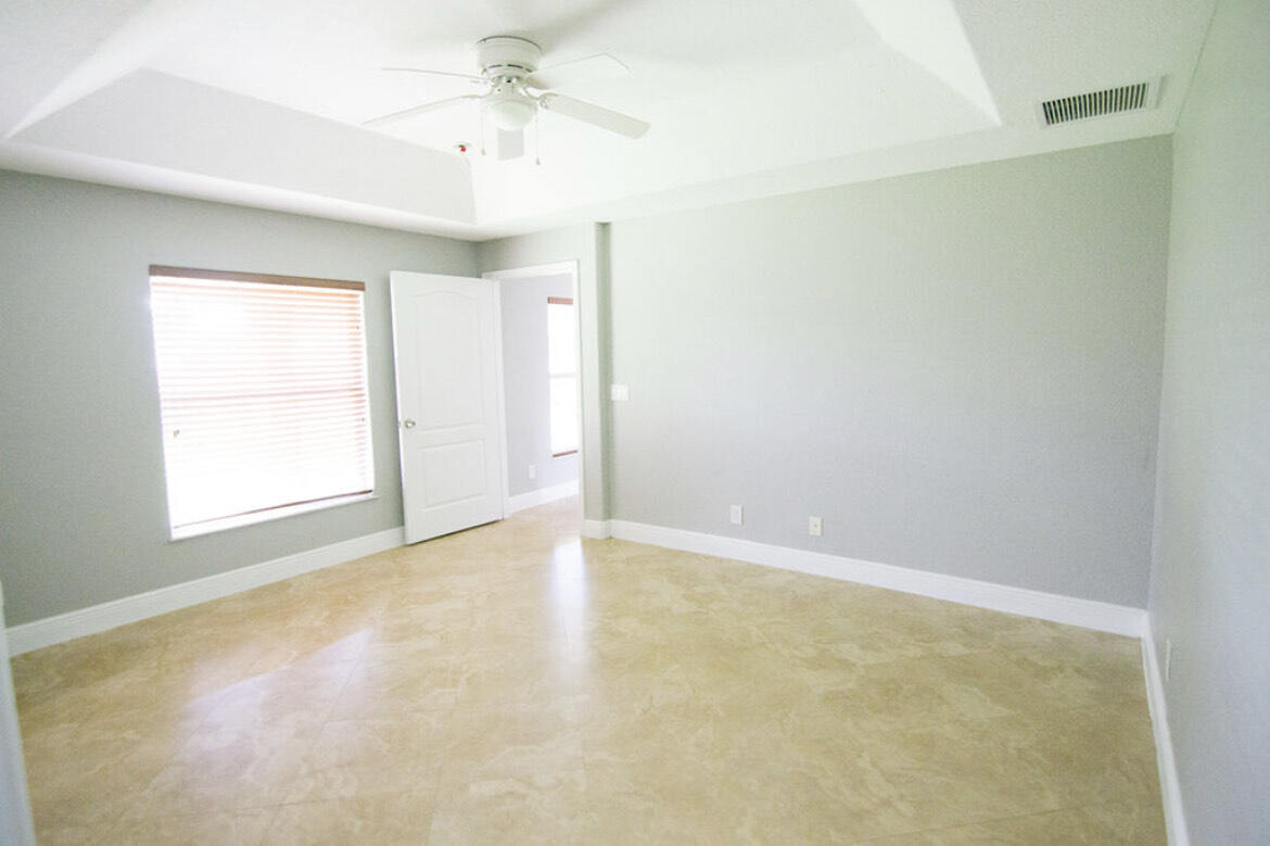 558 Southwest Colleen Avenue Port St. Lucie, FL 34983 - Photo 4 of 8 an empty room with a window and a fan
