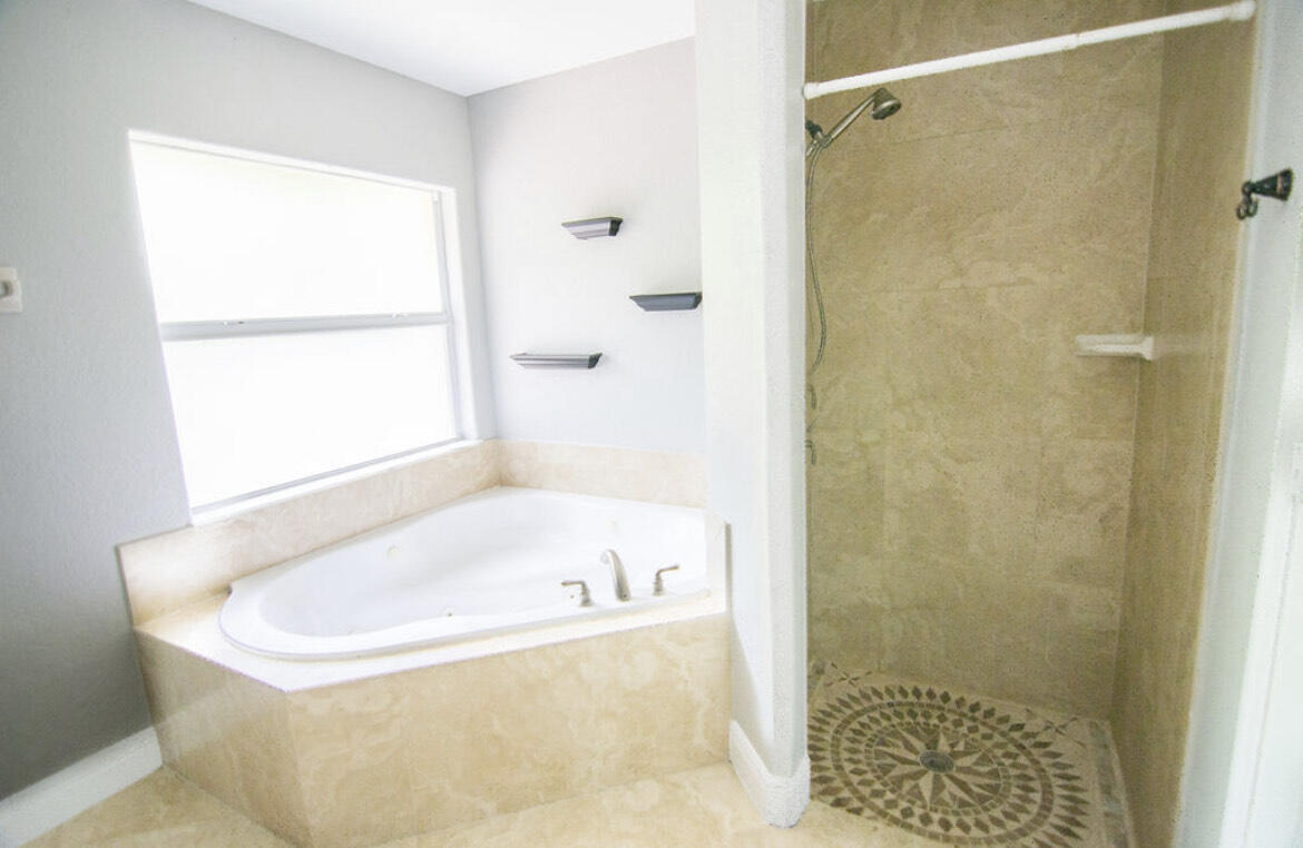558 Southwest Colleen Avenue Port St. Lucie, FL 34983 - Photo 5 of 8 a white bath tub sitting next to a shower