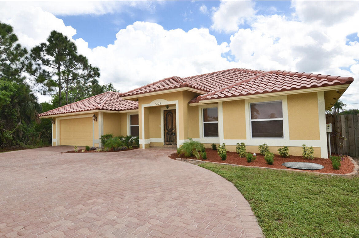 558 Southwest Colleen Avenue Port St. Lucie, FL 34983 - Photo 8 of 8 a front view of a house with a garden and yard