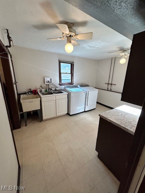 Laundry room with washer and clothes dryer, a sink, cabinet space, and a ceiling fan