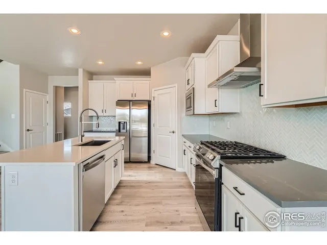 a kitchen with granite countertop a sink stainless steel appliances and cabinets