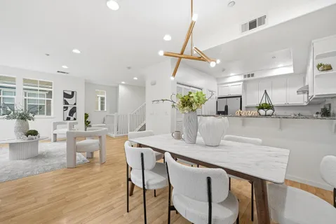 a kitchen with a table chairs refrigerator and cabinets
