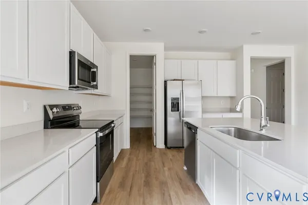 a kitchen with stainless steel appliances granite countertop a sink stove microwave and refrigerator