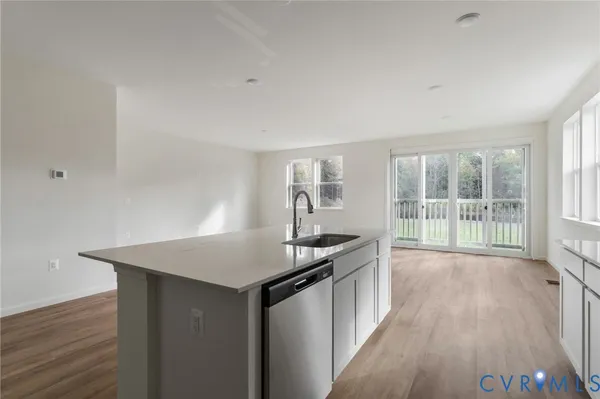 a kitchen with granite countertop a sink and wooden floor
