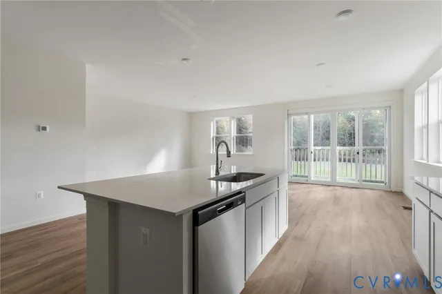 a kitchen with granite countertop a sink and wooden floor