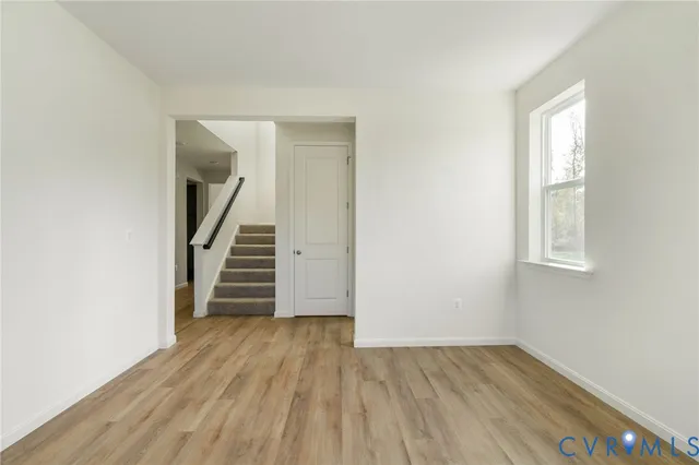 an empty room with wooden floor and stairs