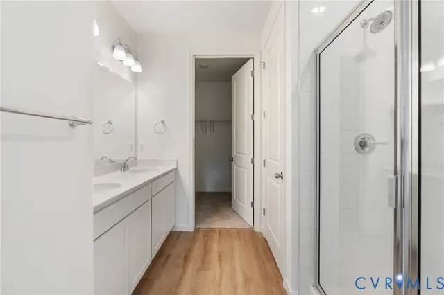 a bathroom with a double vanity sink and mirror with shower
