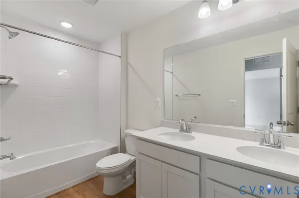 a bathroom with a double vanity sink toilet mirror and shower