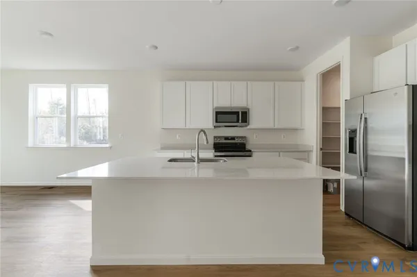 a kitchen with kitchen island a counter top space a sink and stainless steel appliances