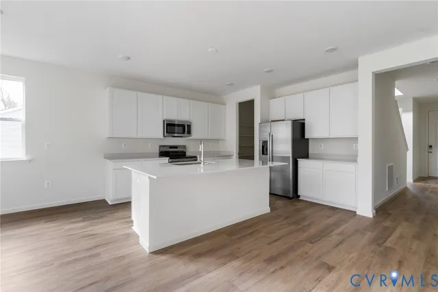 a kitchen with stainless steel appliances a refrigerator and a stove top oven